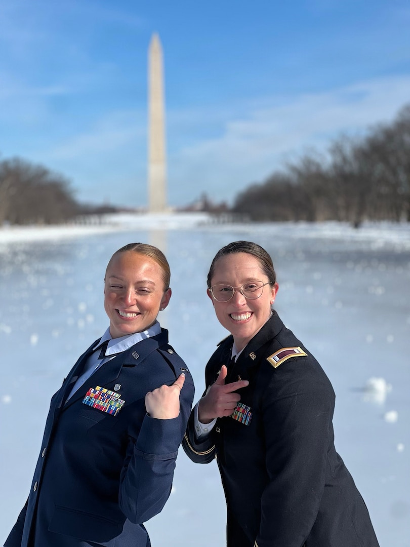 Two female service members pointing to their rank.