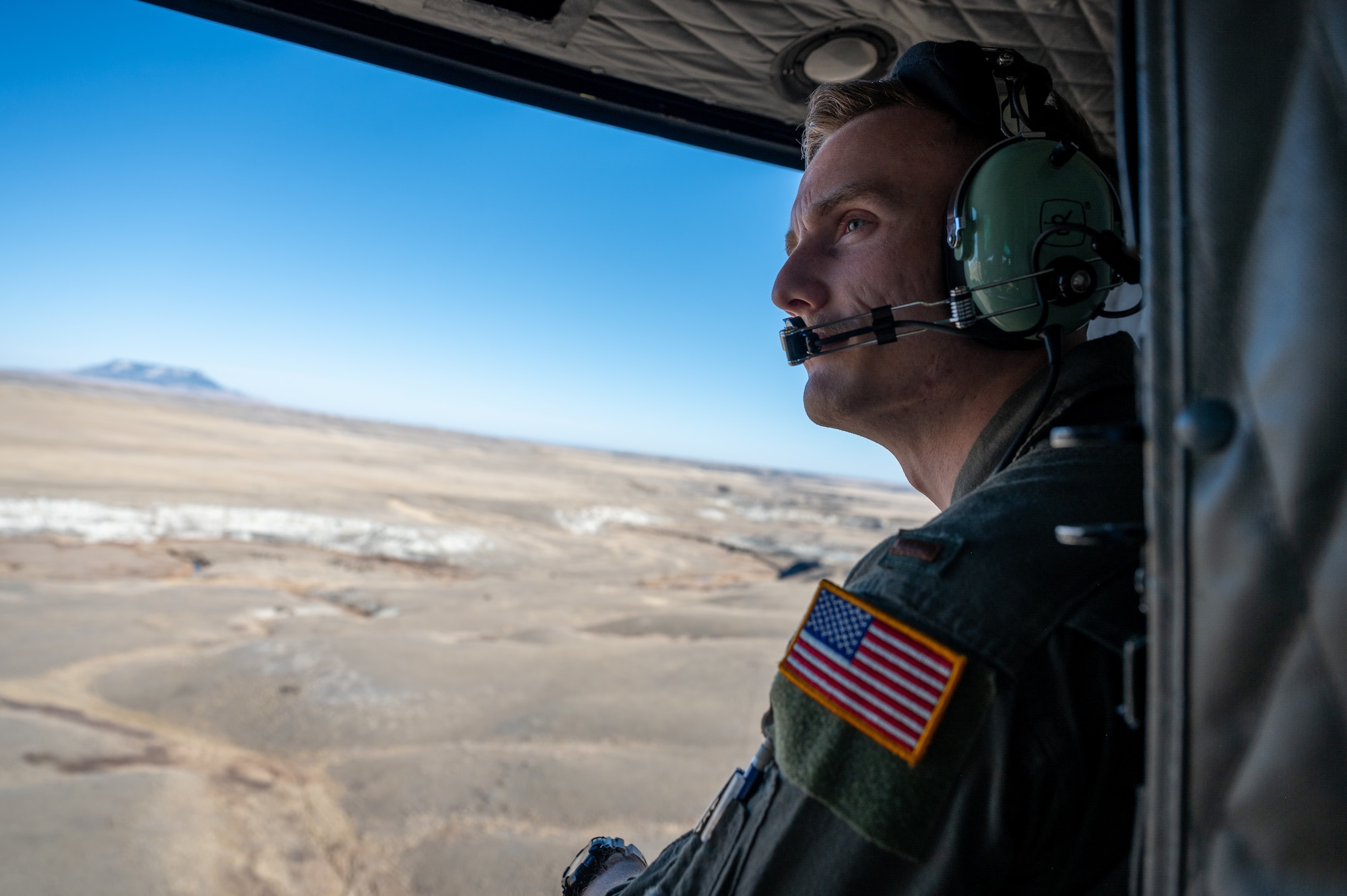 A man in uniform sits in a helicopter.