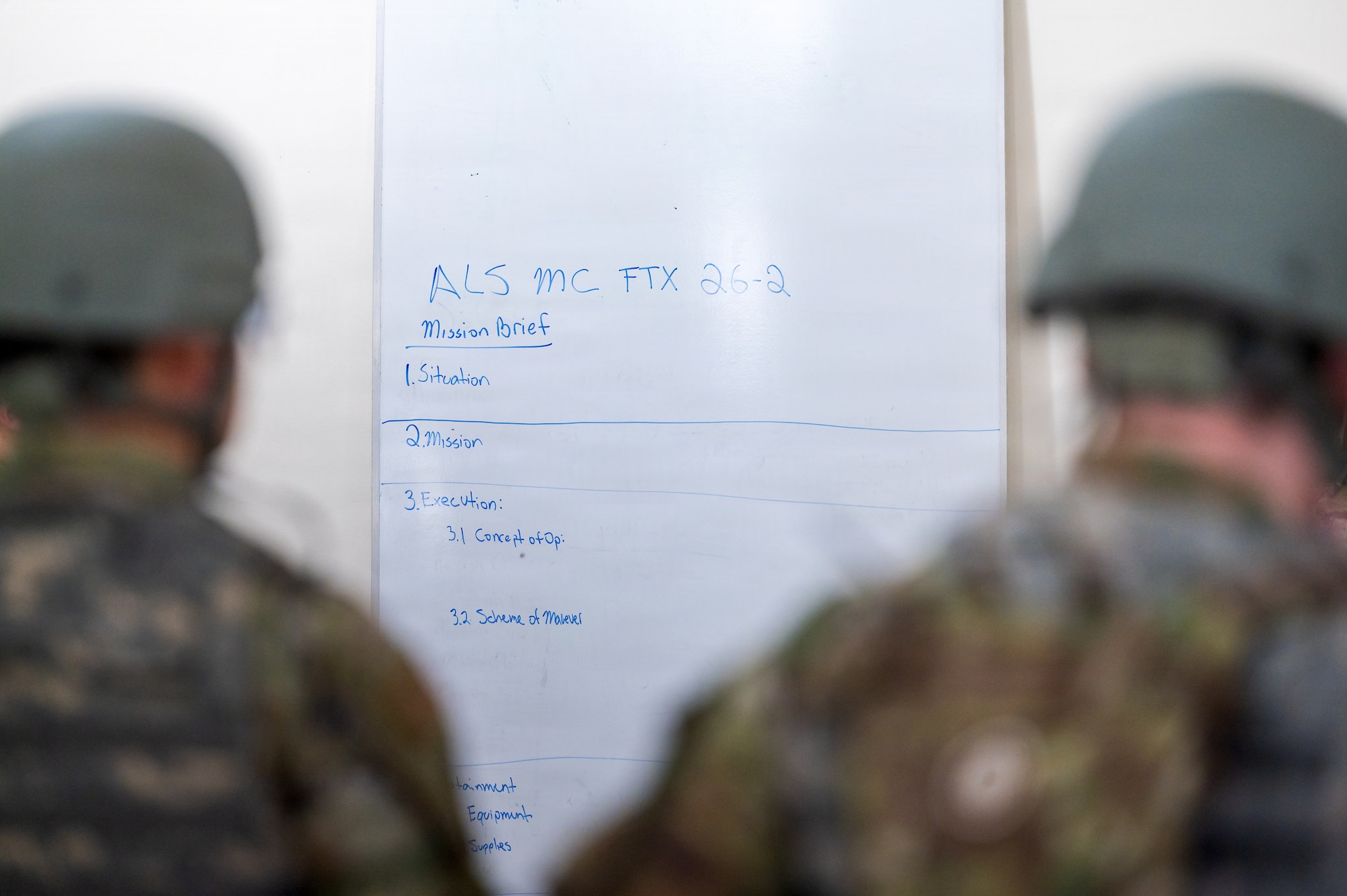 Airman Leadership School students review a mission brief during a field training exercise at Malabar Training Site, Florida, Feb. 5, 2026. The training emphasized Agile Combat Employment concepts by requiring students to operate beyond their primary career fields in a high-stress environment. (U.S. Space Force photo by Gwen Kurzen)
