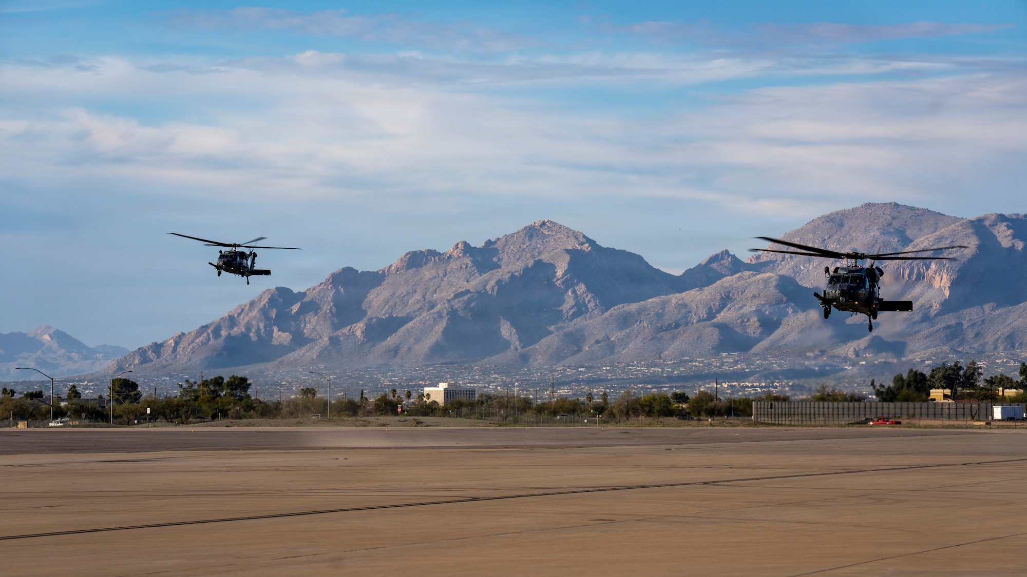 Two U.S. Air Force HH-60W Jolly Green II helicopters assigned to the 55th Rescue Squadron return to Davis-Monthan Air Force Base, Arizona, following a successful rescue mission, Feb. 5, 2026. Supported by an HC-130J Combat King II assigned to the 79th RQS, the extended distance required detailed mission planning, multiple helicopter air refuelings, and close coordination across aircrews, pararescue teams and tanker crews. (U.S. Air Force photo by Andrea Jenkins)