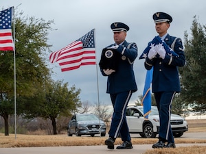 U.S. Air Force Airman 1st Class Jovel Galindo, 7th Force Support Squadron ceremonial guardsman, carries the cremated remains of a fallen U.S. Air Force Veteran while U.S. Air Force Airman 1st Class Nickey Phanhsopha, 7th FSS ceremonial guardsman, carries a folded U.S. flag during a funeral service at the Texas State Veterans Cemetery in Abilene, Texas, Jan. 13, 2026. The Dyess Air Force Base Honor Guard represents the Air Force at ceremonies, funerals and official events across 38 counties throughout West and Central Texas. (U.S. Air Force photo by Airman William Neal)