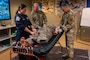 U.S. Air Force Tech. Sgt. Michelle Westerman, left, 2nd Healthcare Operations Squadron paramedic, demonstrates tactical combat casualty care procedures for Gen. S. L. Davis, center, commander of Air Force Global Strike Command, and Chief Master Sgt. Shawn M. Aiello, AFGSC command chief, at Barksdale Air Force Base, Louisiana, Feb. 2, 2026. Davis and Aiello gained further insight into the role of paramedics during their visit and how they contribute to the success of the 2 BW mission. (U.S. Air Force photo by Senior Airman Seth Watson)