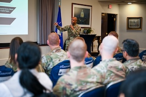 U.S. Air Force Chief Master Sgt. Anthony Thompson Jr., senior enlisted leader for Joint Base Anacostia-Bolling and 11th Wing command chief, discusses readiness during a wing all-call at JBAB, Washington, D.C., Jan. 13, 2026. He used a coin to explain that personal readiness and professional readiness go hand in hand with each other. (U.S. Air Force photo by Airman 1st Class Shanel Toussaint)