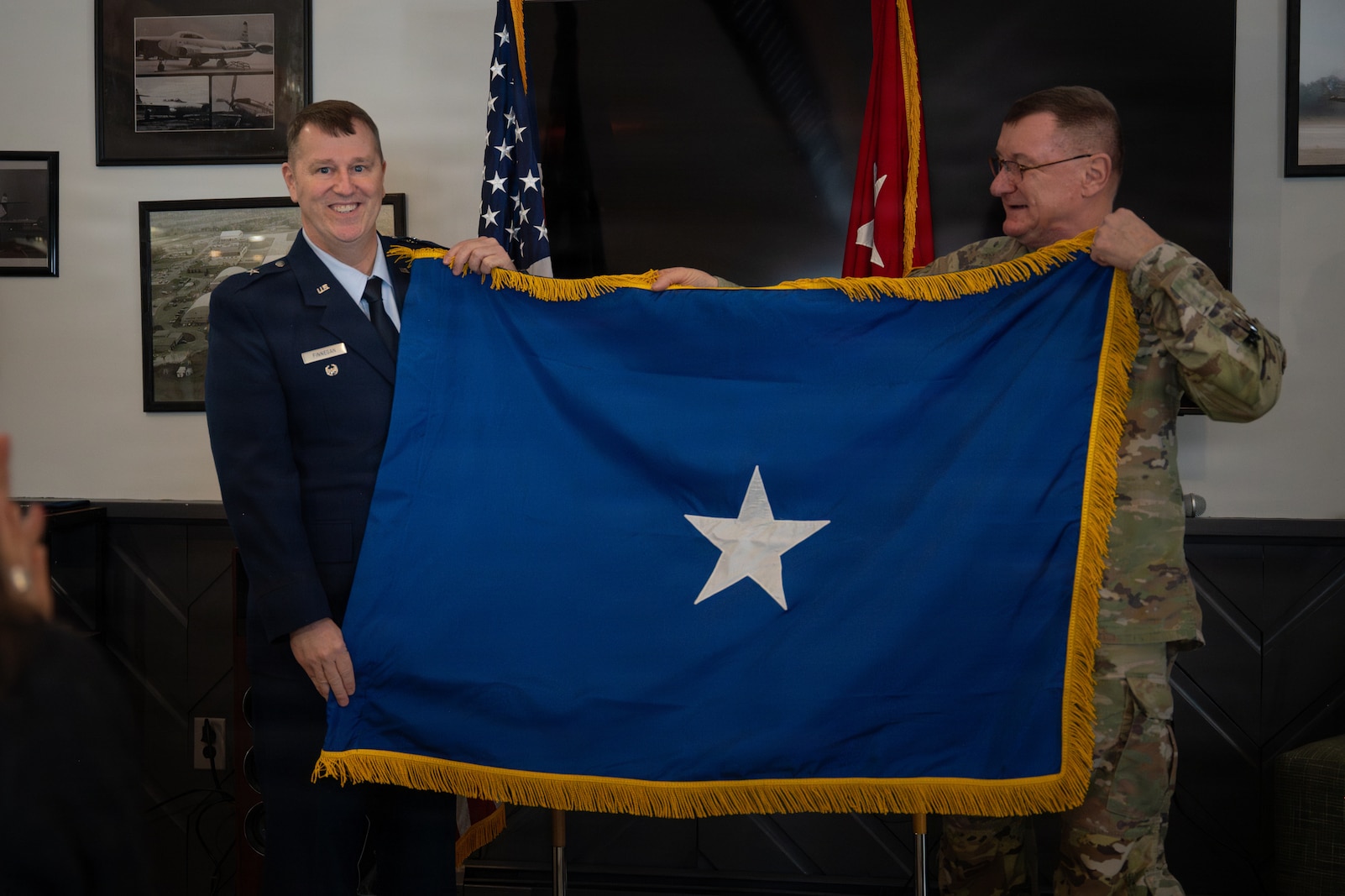 U.S. Air Force Brig. Gen. Daniel Finnegan and U.S. Army Maj. Gen. Gregory Knight, adjutant general of the Vermont National Guard, hold the one star flag after being promoted to the rank of brigadier general at the Vermont Air National Guard Base in South Burlington, Vermont.