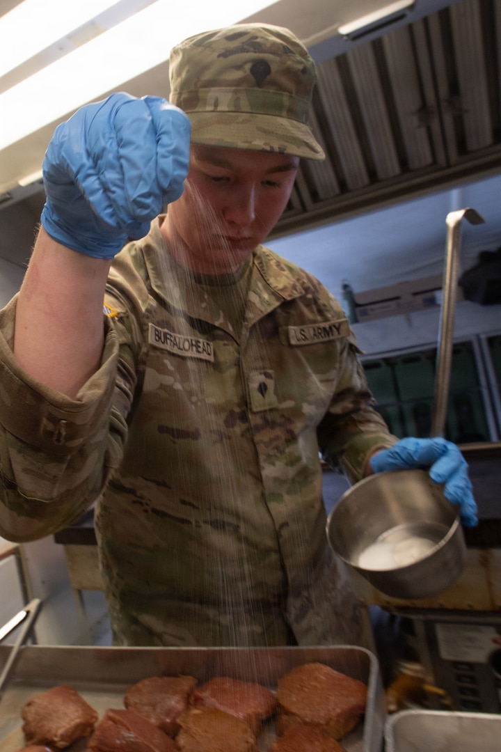 Spc. Brayden Buffalohead, a member of the 903rd Quartermaster Company, seasons steaks during the third annual Oklahoma Army National Guard Culinary Excellence Competition, in Norman, Oklahoma, Feb. 8, 2026. Buffalohead is one of the five cooks on a team representing the 903rd who took first place in the competition - the third time in a row a team representing the 903rd has placed first in the competition designed to recognize outstanding OKARNG cooks. (Oklahoma National Guard photo by Staff Sgt. Anthony Jones)