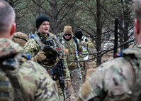 U.S. Air Force 1st Lt. Cole Lautt (center left), 91st Missile Security Operations Squadron (91MSOS) convoy response force flight commander, discusses tactics with his team during a force-on-force exercise at Garrison, North Dakota, Feb. 6, 2026. Lautt emphasized the importance of clear communication and teamwork for mission success. (U.S. Air Force photo by Senior Airman Kyle Wilson)