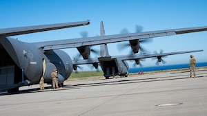 Two U.S. Air Force C-130J Super Hercules assigned to the 19th Airlift Wing and 317th Airlift Wing remain running while U.S. Marines assigned to Marine Wing Support Squadron 372 prepare fuel lines during Specialized Fueling Operations at Naval Landing Field, San Clemente Island, California, Feb. 4, 2026. The training validated repeatable joint fueling procedures in support of distributed operations during the Spring 2026 C-130 Weapon System Council led by the 317th AW. (U.S. Air Force photo by Senior Airman Jade M. Caldwell)
