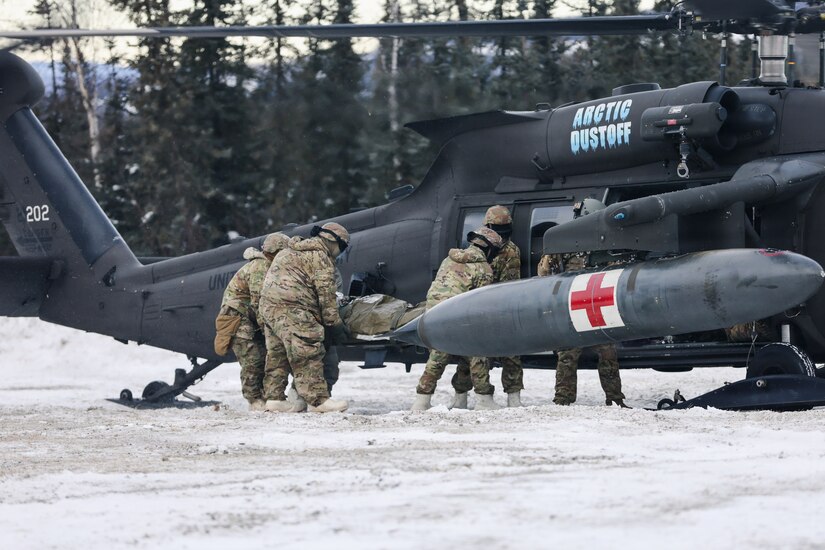 U.S. Army Soldiers assigned to 2nd Infantry Brigade Combat Team (Airborne),11th Airborne Division load a simulated casualty onto a UH-60 Black Hawk during a medical evacuation rehearsal at Yukon Training Center, Alaska, Feb. 10, 2026.