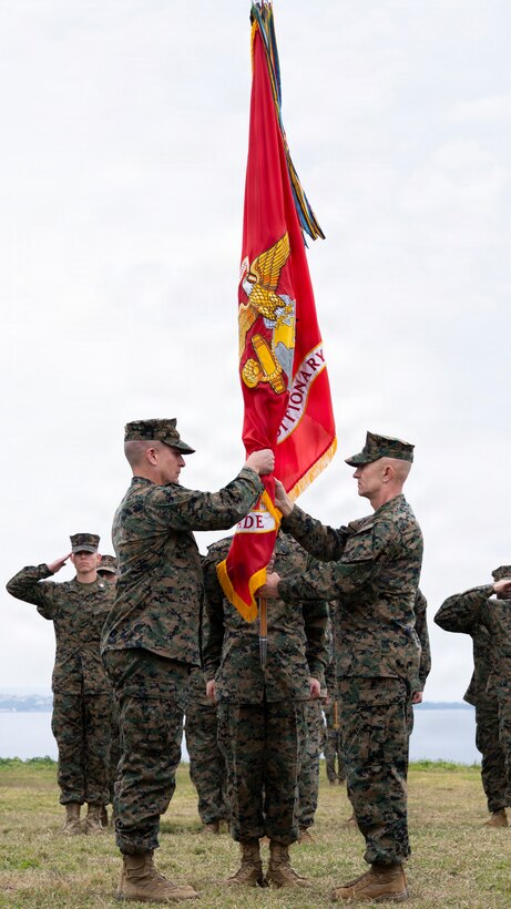 U.S. Marine Corps Brig. Gen. Robert Brodie, right, the offgoing commanding general of 3rd Marine Expeditionary Brigade, holds the command colors before passing them on to Brig. Gen. Ryan Hoyle, the oncoming commanding general of 3rd MEB, Camp Courtney, Okinawa, Japan, Feb. 6, 2026. 3rd MEB hosted the change of command ceremony to formally recognize the total transfer of authority from Brig. Gen. Robert Brodie to Brig. Gen. Ryan Hoyle. The unit conducts combined operations, exercises, and training in support of the III Marine Expeditionary Force to strengthen alliance relationships and enhance regional security. (U.S. Marine Corps photo by Staff Sgt. Shannon Doherty)