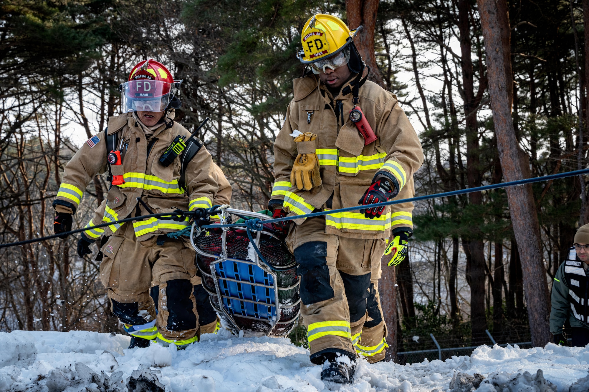 U.S. Air Force Airman 1st Class Josiah Smith, right, and Tadakatsu Kumagai, 35th Civil Engineer Squadron (CES) firefighters, carry a dummy on a stretcher away from a simulated car wreck during an inter-unit casualty and vehicle recovery exercise.
