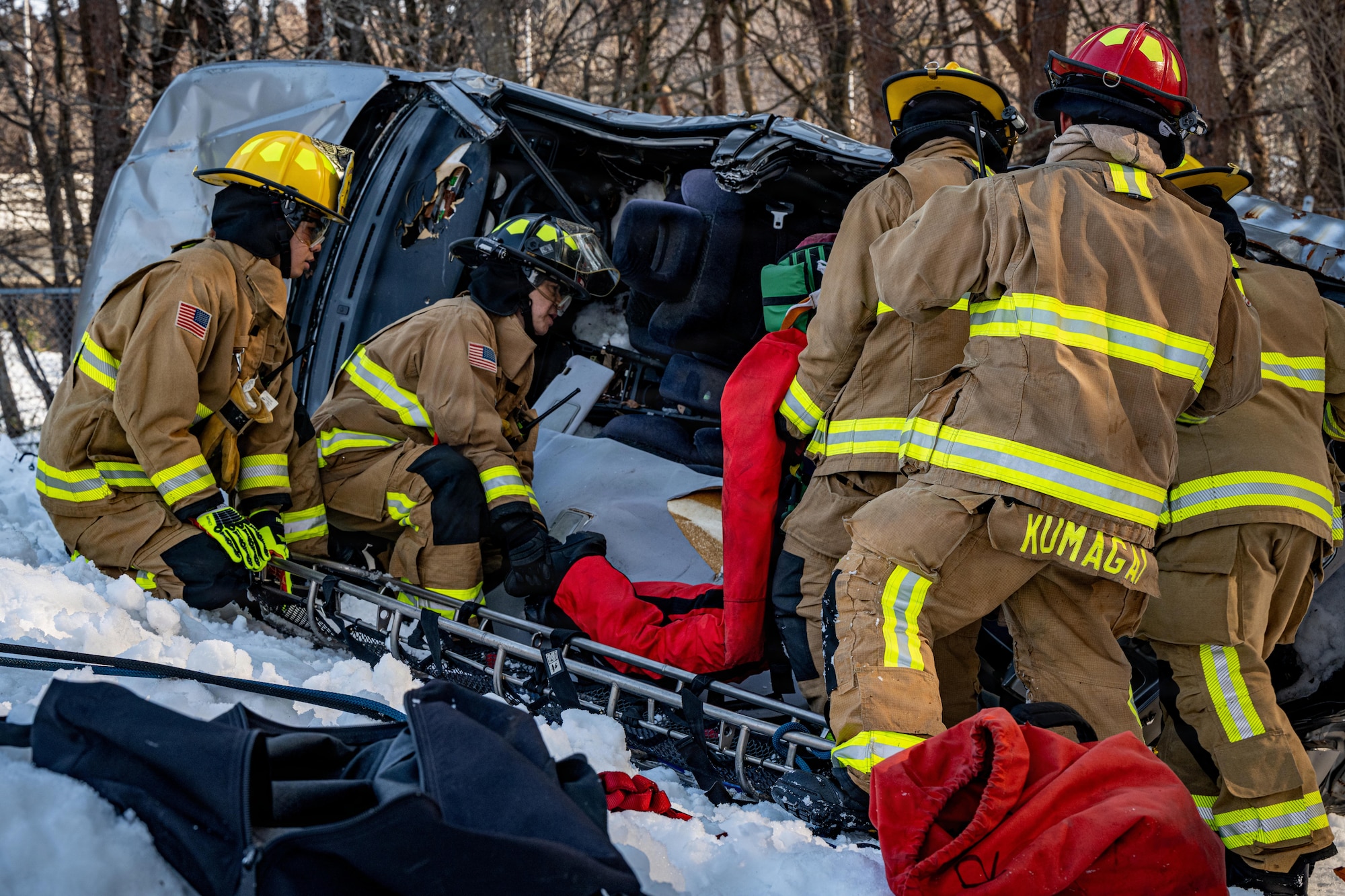 U.S. Airmen assigned to the 35th Civil Engineer Squadron (CES) lift a patient dummy out of a simulated car wreck during an inter-unit casualty and vehicle recovery exercise.