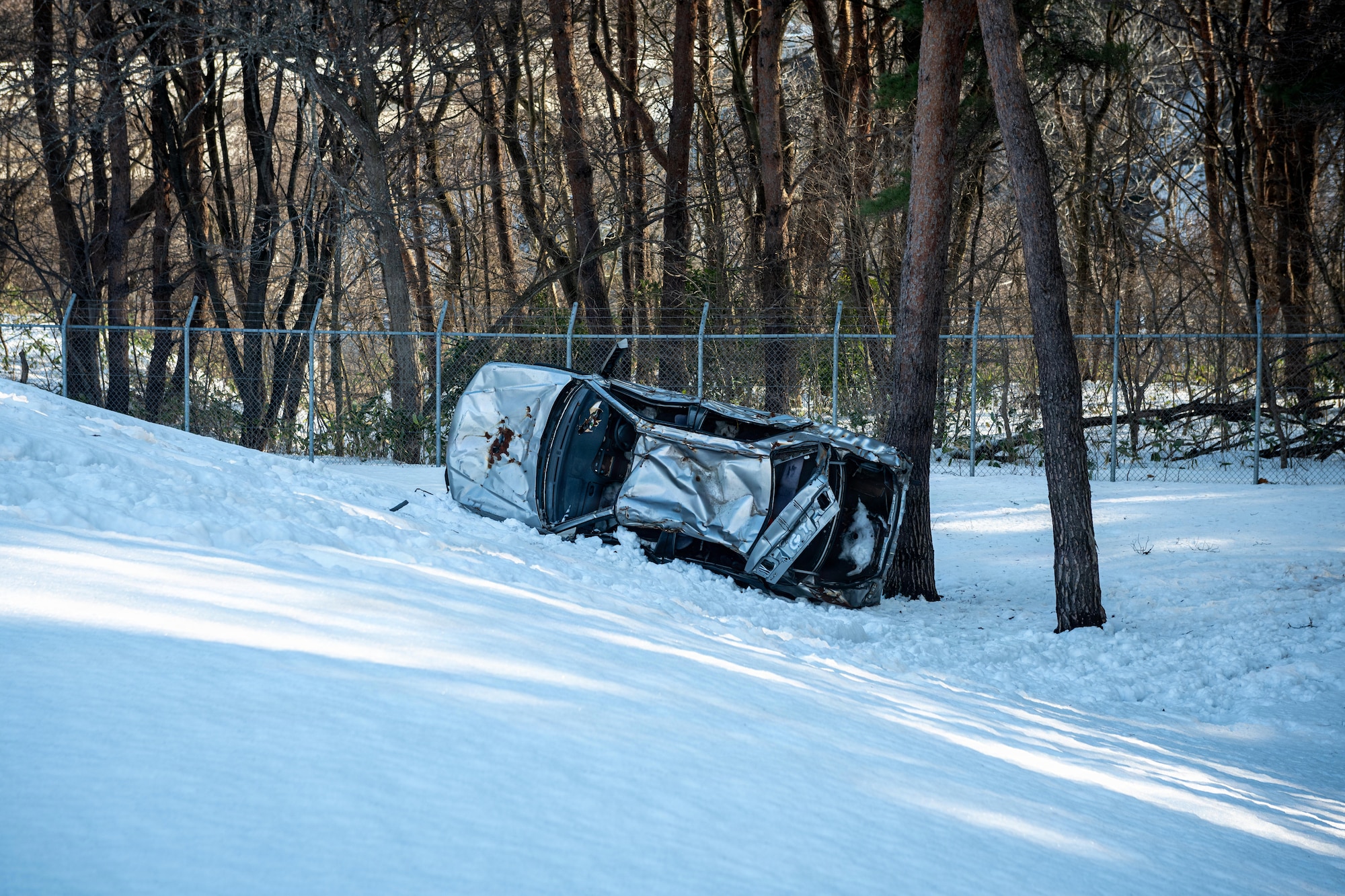 A simulated car wreck lays off the side of the road during an inter-unit casualty and vehicle recovery exercise.