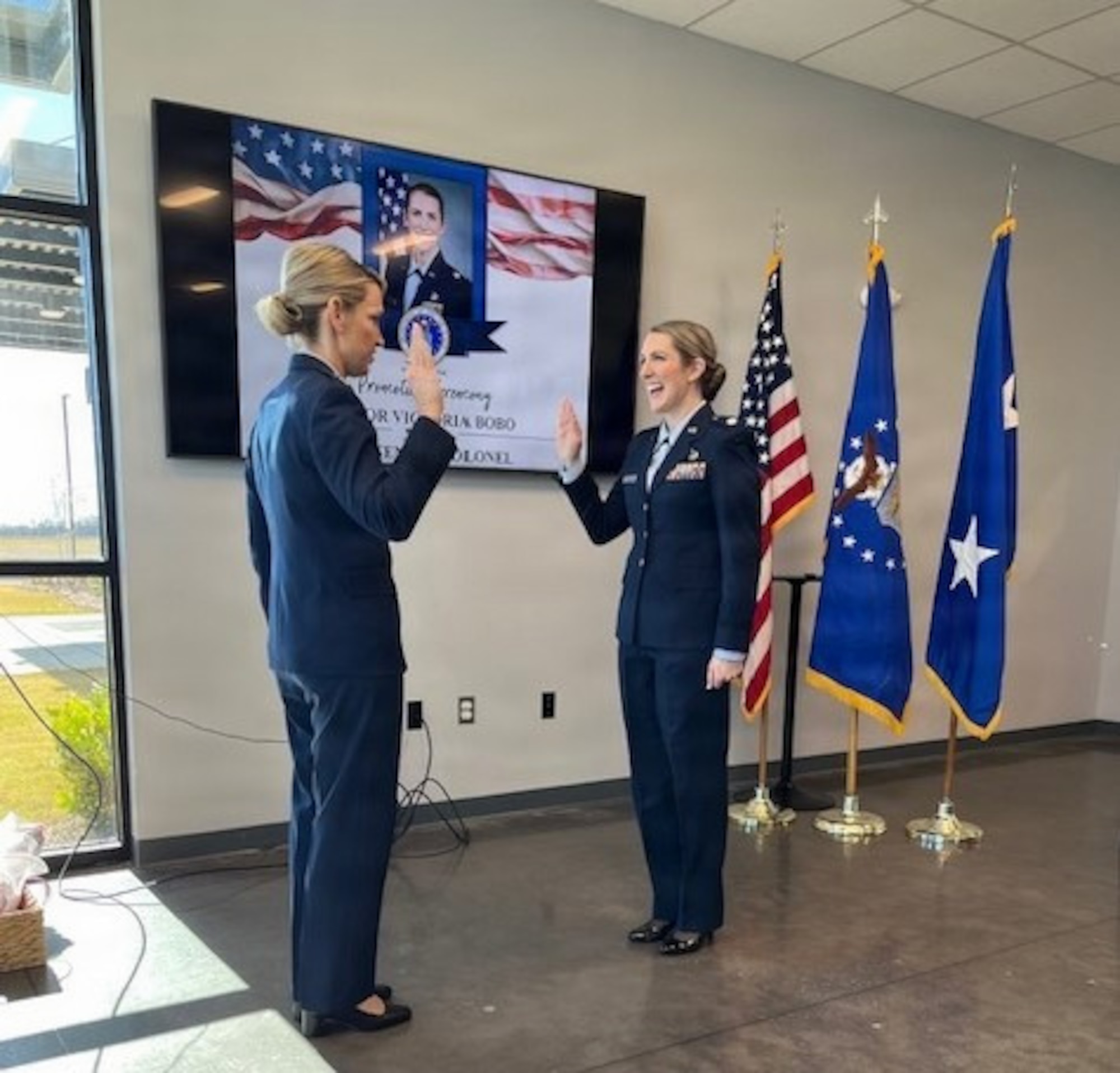 Two women in air force blues during a promotion ceremony.