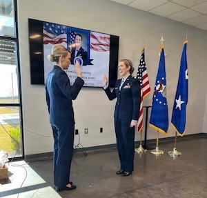 Two women in air force blues during a promotion ceremony.