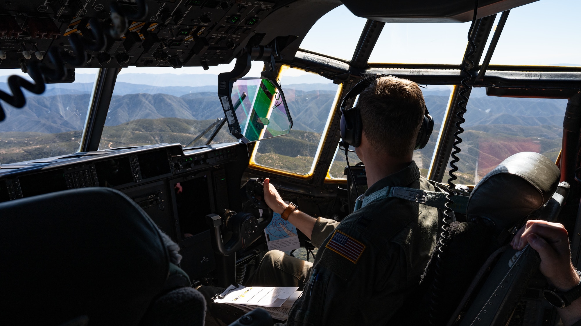 U.S. Air Force Capt. Reece Cooke, 40th Airlift Squadron pilot, observes terrain from a C-130J Super Hercules during low-level flight over the Peninsular Ranges, California, Feb. 4, 2026. The aircraft carried an ultra-light tactical vehicle and U.S. Marines assigned to Marine Wing Support Squadron 372, providing realistic joint training during the Spring 2026 C-130 Weapon System Council led by the 317th Airlift Wing. (U.S. Air Force photo by Senior Airman Jade M. Caldwell)