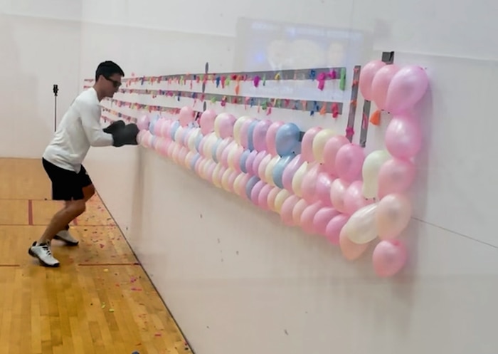 Maj. Jonathan Buckingham sets the Guinness World Record for most balloons burst with boxing gloves in one minute, her, July 12, 2025. Buckingham has set a total of 17 Guinness World Records and has three currently pending. Buckingham is a program manager for Kessel Run, a division that is part of the Department of the Air Force Portfolio Acquisition Executive for Command, Control, Communication and Battle Management. (Courtesy image).