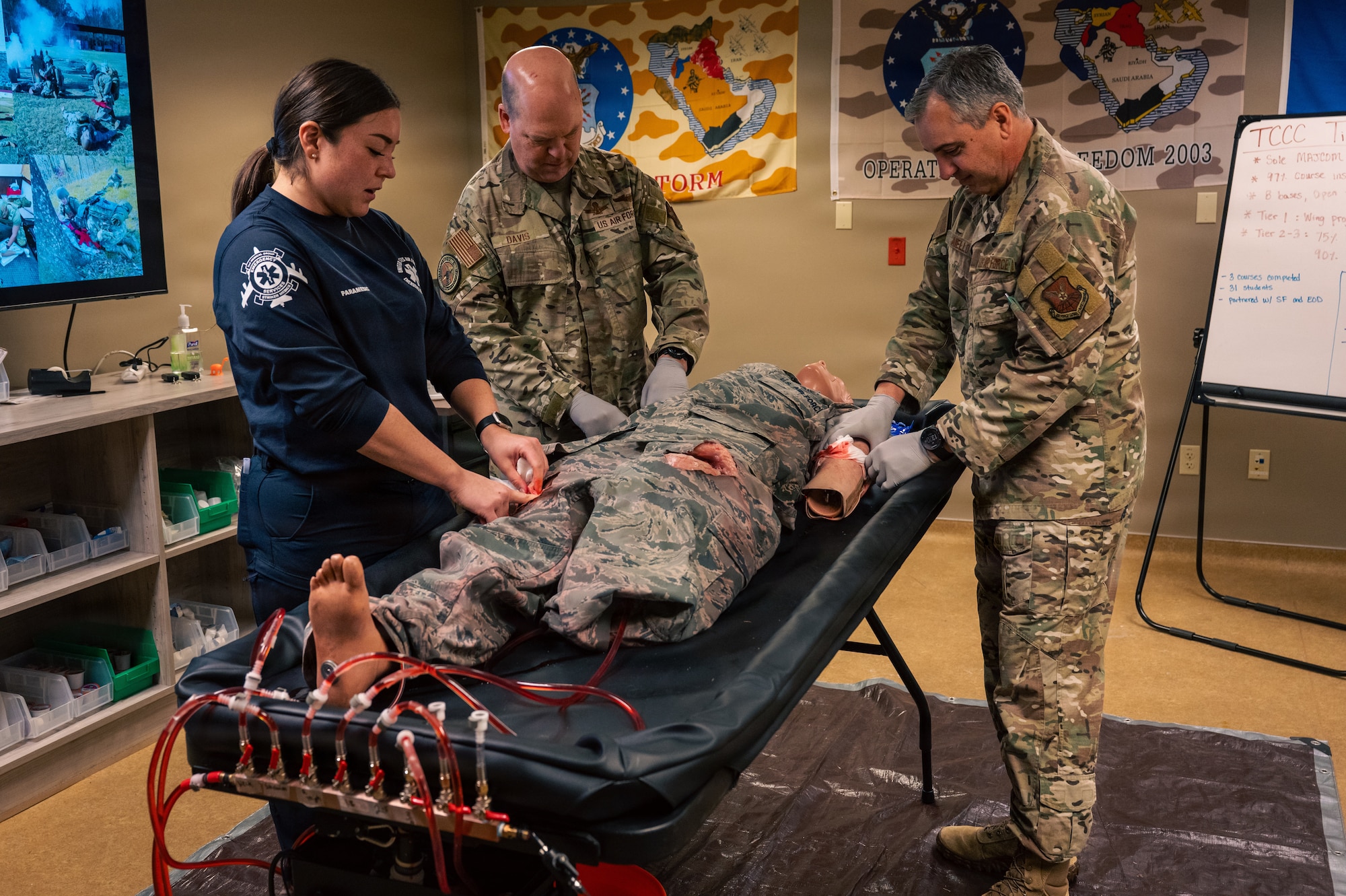 U.S. Air Force Tech. Sgt. Michelle Westerman, left, 2nd Healthcare Operations Squadron paramedic, demonstrates tactical combat casualty care procedures for Gen. S. L. Davis, center, commander of Air Force Global Strike Command, and Chief Master Sgt. Shawn M. Aiello, AFGSC command chief, at Barksdale Air Force Base, Louisiana, Feb. 2, 2026. Davis and Aiello gained further insight into the role of paramedics during their visit and how they contribute to the success of the 2 BW mission. (U.S. Air Force photo by Senior Airman Seth Watson)