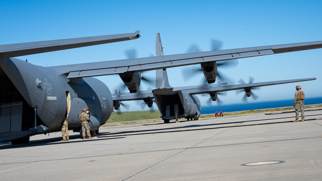 Two U.S. Air Force C-130J Super Hercules assigned to the 19th Airlift Wing and 317th Airlift Wing remain running while U.S. Marines assigned to Marine Wing Support Squadron 372 prepare fuel lines during Specialized Fueling Operations at Naval Landing Field, San Clemente Island, California, Feb. 4, 2026. The training validated repeatable joint fueling procedures in support of distributed operations during the Spring 2026 C-130 Weapon System Council led by the 317th AW. (U.S. Air Force photo by Senior Airman Jade M. Caldwell)