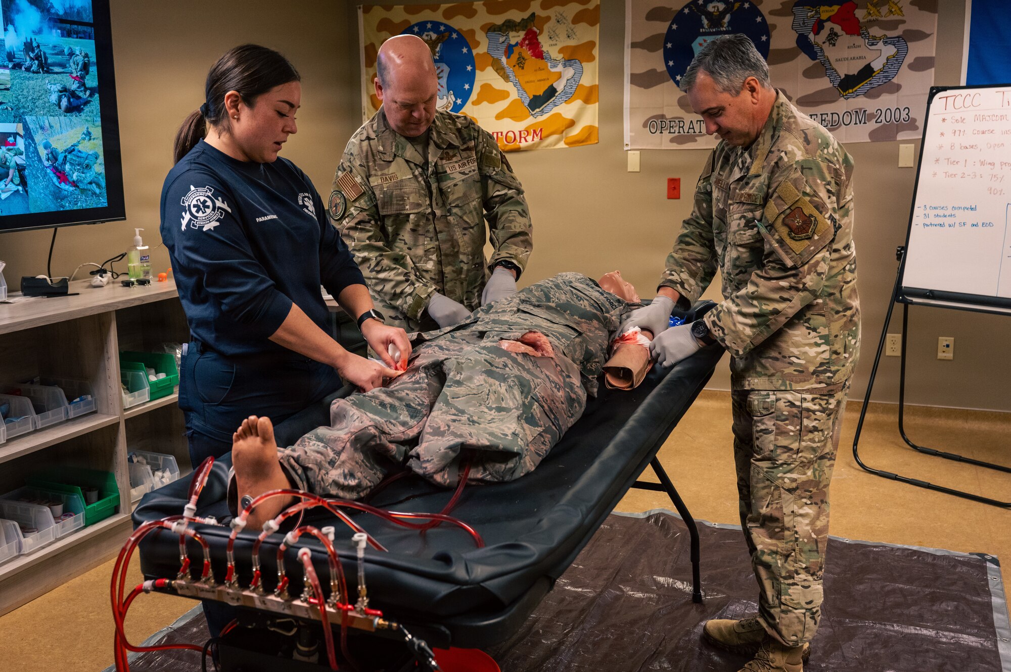 U.S. Air Force Tech. Sgt. Michelle Westerman, left, 2nd Healthcare Operations Squadron paramedic, demonstrates tactical combat casualty care procedures for Gen. S. L. Davis, center, commander of Air Force Global Strike Command, and Chief Master Sgt. Shawn M. Aiello, AFGSC command chief, at Barksdale Air Force Base, Louisiana, Feb. 2, 2026. Davis and Aiello gained further insight into the role of paramedics during their visit and how they contribute to the success of the 2 BW mission. (U.S. Air Force photo by Senior Airman Seth Watson)