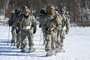 Airmen walk through the snow.