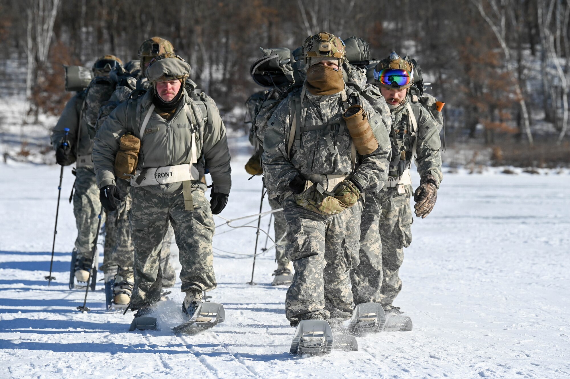 Airmen walk through the snow.