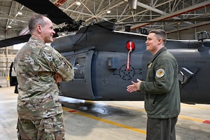 U.S. Air Force Maj. Gen. Jefferson O’Donnell receives a tour around a helicopter.