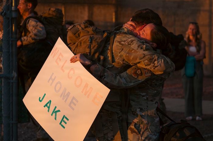 One U.S. Air Force Airman welcomes another home upon their return from a months-long deployment in the Middle East at Davis-Monthan Air Force Base, Arizona, Feb. 6, 2026. The reunion marked the end of months of separation for the 55th Rescue Squadron in support of overseas operations in the Middle East. (U.S. Air Force photo by Airman 1st Class Samantha Melecio)