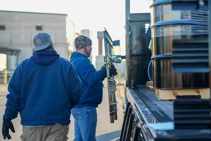Man removes the side gate of a truck