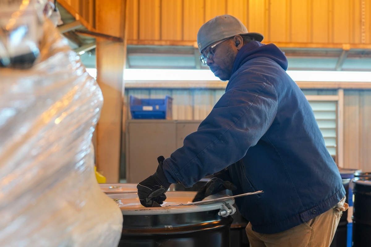 Man assesses a hazardous waste drum