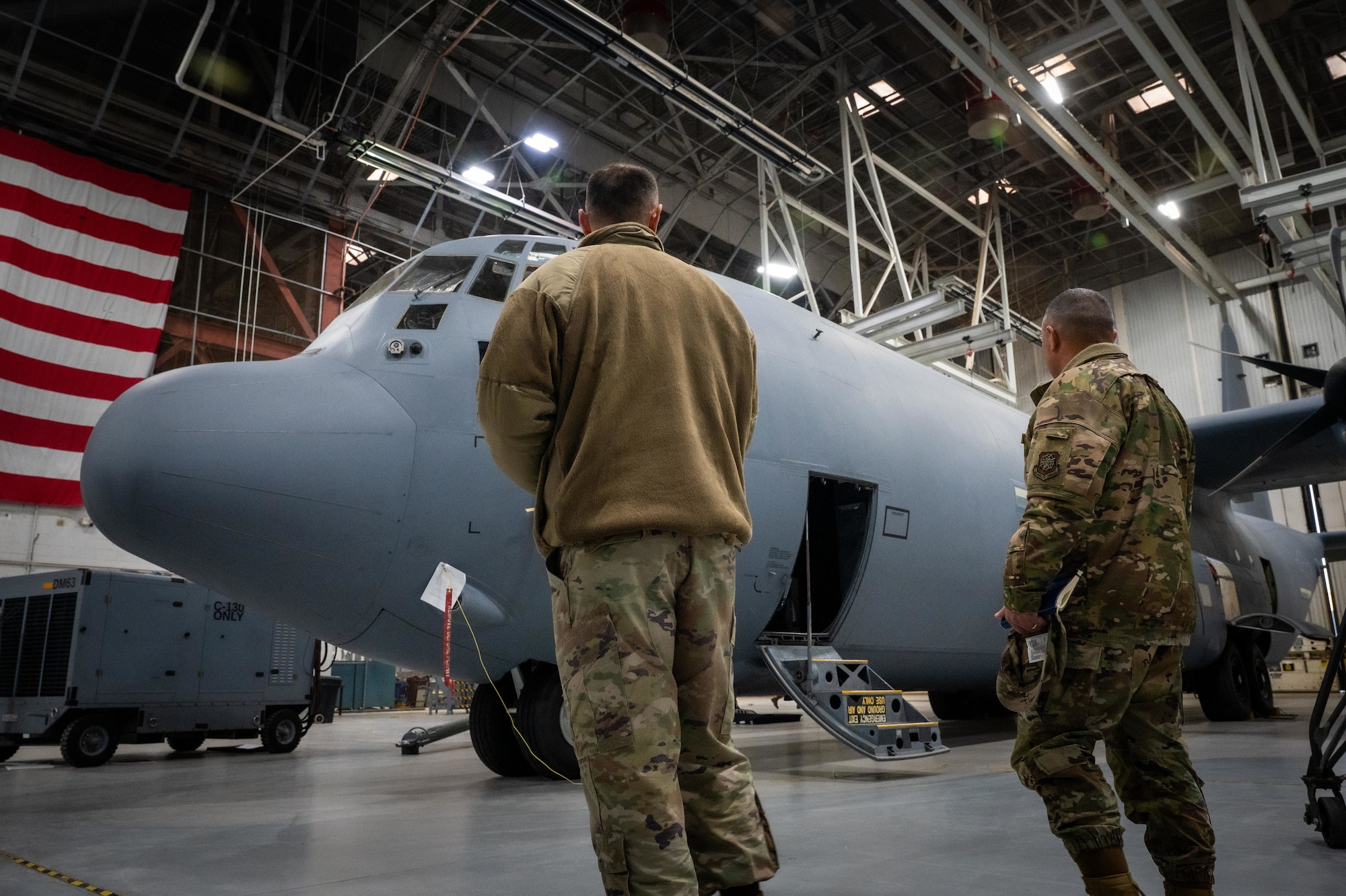 U.S. Air Force Senior Master Sgt. Bruce Sheatler, 317th Maintenance Squadron senior enlisted leader, discuss C-130J Super Hercules external fuel tank operations with Chief Master Sgt. Joseph Arce, 18th Air Force command chief, at Dyess Air Force Base, Texas, Jan. 30, 2026. The briefing highlighted how the 317th Airlift Wing is pioneering new tactics to increase airlift range and sustain joint forces across the Indo-Pacific. (U.S. Air Force photo by Airman William Neal)