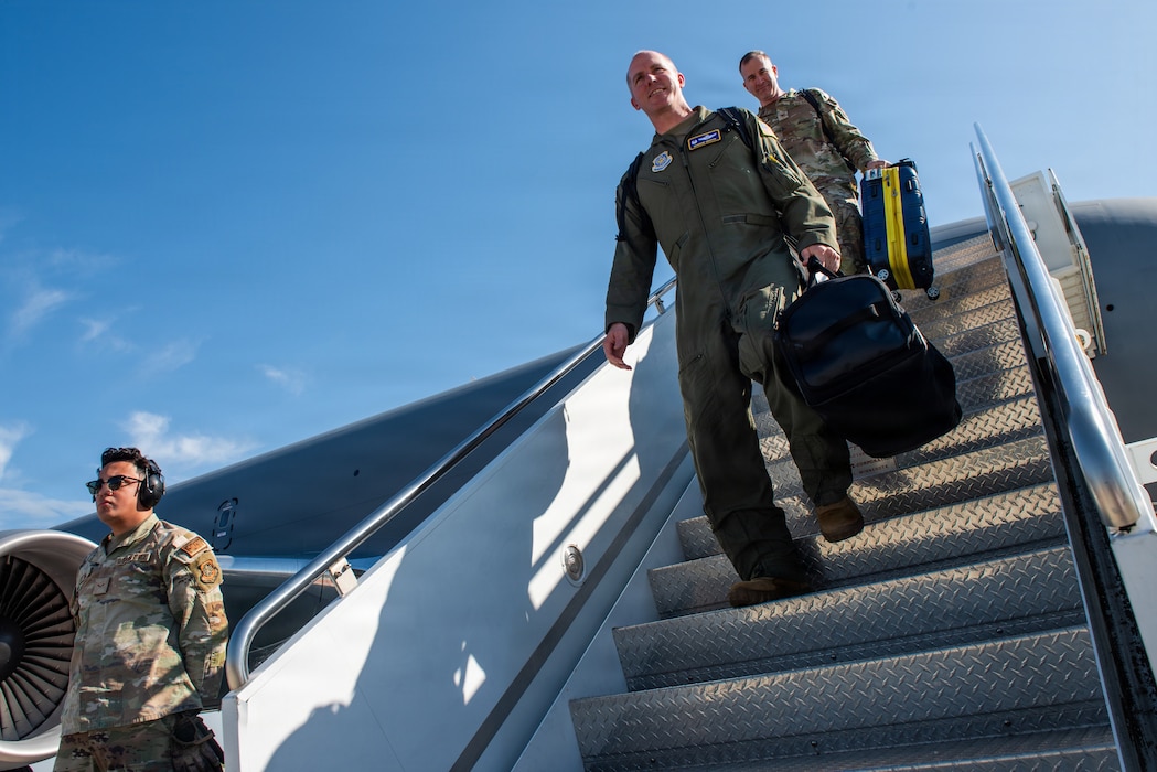 Commander's disembark aircraft using stairs.