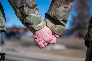 Photo of two U.S. military members holding hands.