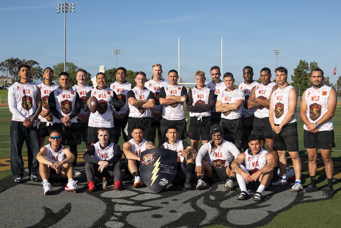 U.S. Marines with 9th Communication Battalion, I Marine Expeditionary Force Information Group, pose for a photo with the I MIG HMMR Bowl shield at Marine Corps Base Camp Pendleton, California, Feb. 6, 2026. The HMMR Bowl, named after the I MIG motto of honor, courage, commitment; mission; Marines; readiness, is an annual competition where I MIG Marines compete in flag football and a sports combine events to demonstrate physical prowess, camaraderie, and espirit de corps. (U.S. Marine Corps photo by Lance Cpl. Fabian Ortiz)