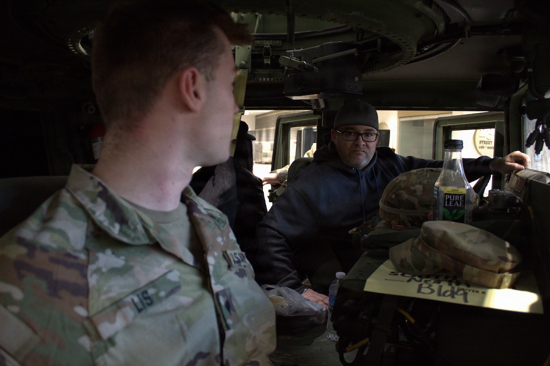 Spc. Christian Lis speaks with David Nelson, a plumber with local 130, at the Chicago Auto Show.