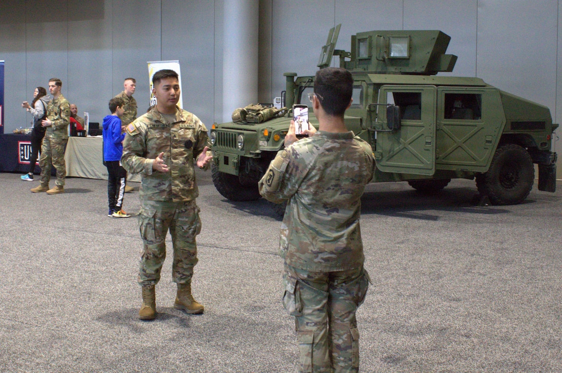 Spc Alvin Gonzalez takes a video of Sgt Luigi Cabantog at the Chicago Auto Show.