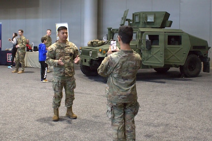 Spc Alvin Gonzalez takes a video of Sgt Luigi Cabantog at the Chicago Auto Show.