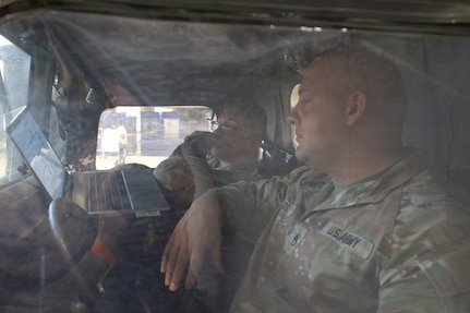Staff Sgt Brian Buss and Staff Sgt Emmanuel Antunez attend a virtual Brigade officer in charge sync in an M1152 at the Chicago Auto Show in Chicago.