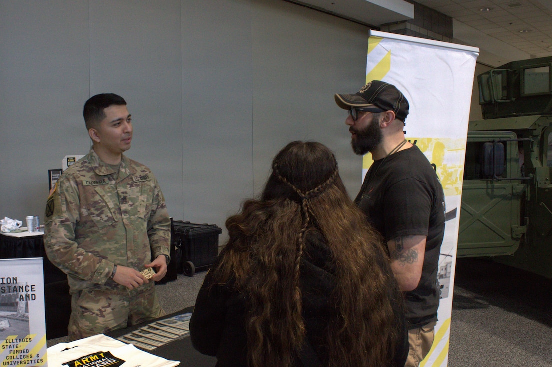 Sgt Patricio Cabrera talks with Eric Morales, a veterans service officer, at the Chicago Auto Show in Chicago.
