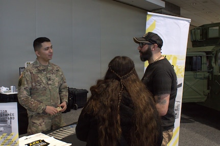 Sgt Patricio Cabrera talks with Eric Morales, a veterans service officer, at the Chicago Auto Show in Chicago.