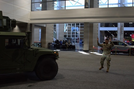 Sgt Luigi Cabantog guides an M1151A1 into place at the Chicago Auto Show in Chicago.
