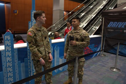 Recruiters with Bravo Company Illinois National Guard Recruiting and Retention Command, wait in line for their chance to test drive a vehicle at the Chicago Auto Show in Chicago.