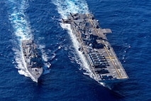 U.S. Navy Arleigh Burke-class guided-missile destroyer USS Rafael Peralta (DDG 115) receives fuel from America-class amphibious assault ship USS Tripoli (LHA 7) during a replenishment at sea in the Philippine Sea, Feb. 10, 2026.