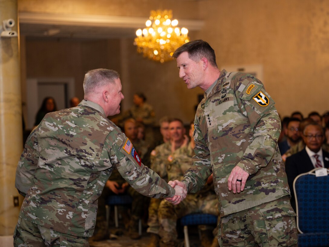 Two men shake hands in uniform