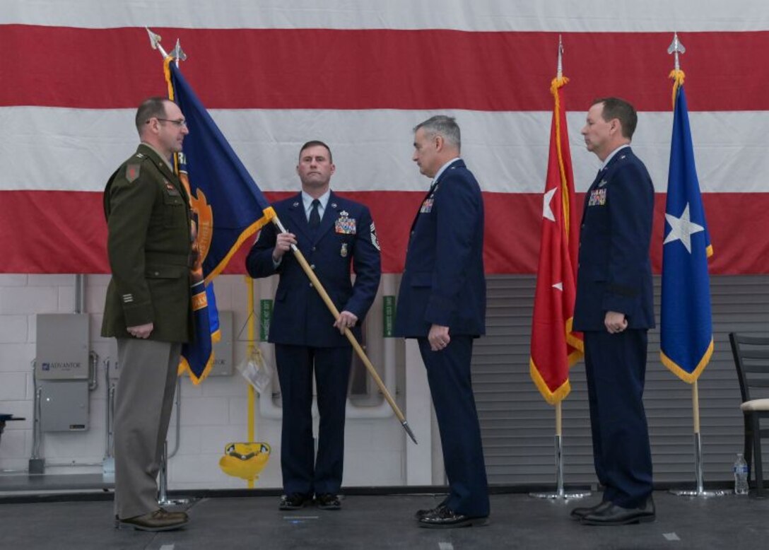 U.S. Army Maj. Gen. Matthew Strub, Wisconsin’s adjutant general, left, initiates the passing of the colors, a tradition symbolizing the exchange of authority between outgoing and incoming commanders during the state’s deputy adjutant general for Air change of command ceremony Feb. 7, at Truax Field in Madison, Wisconsin. During the event, Brig. Gen. Bart Van Roo, former director of strategic plans and operations for the state of Wisconsin, right, replaced Brig. Gen. Erik Peterson as commander of the Wisconsin Air National Guard. (U.S. National Guard photo by Paul Gorman)