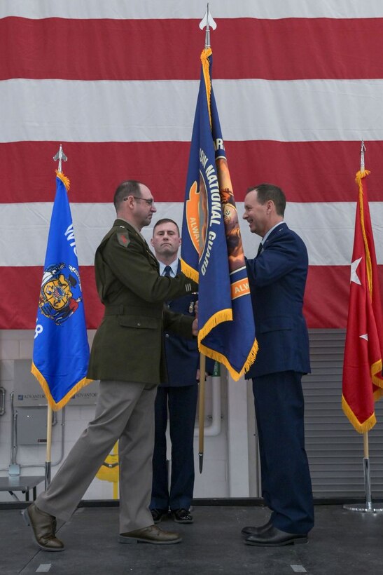 U.S. Army Maj. Gen. Matthew Strub, Wisconsin’s adjutant general, left, passes the colors to Brig. Gen. Bart Van Roo, former director of strategic plans and operations for the state of Wisconsin, symbolizing his appointment as the state’s new deputy adjutant general for Air, during a change of command ceremony Feb. 7, at Truax Field in Madison, Wisconsin. During the event, Van Roo replaced Brig. Gen. Erik Peterson as commander of the Wisconsin Air National Guard. (U.S. National Guard photo by Paul Gorman)
