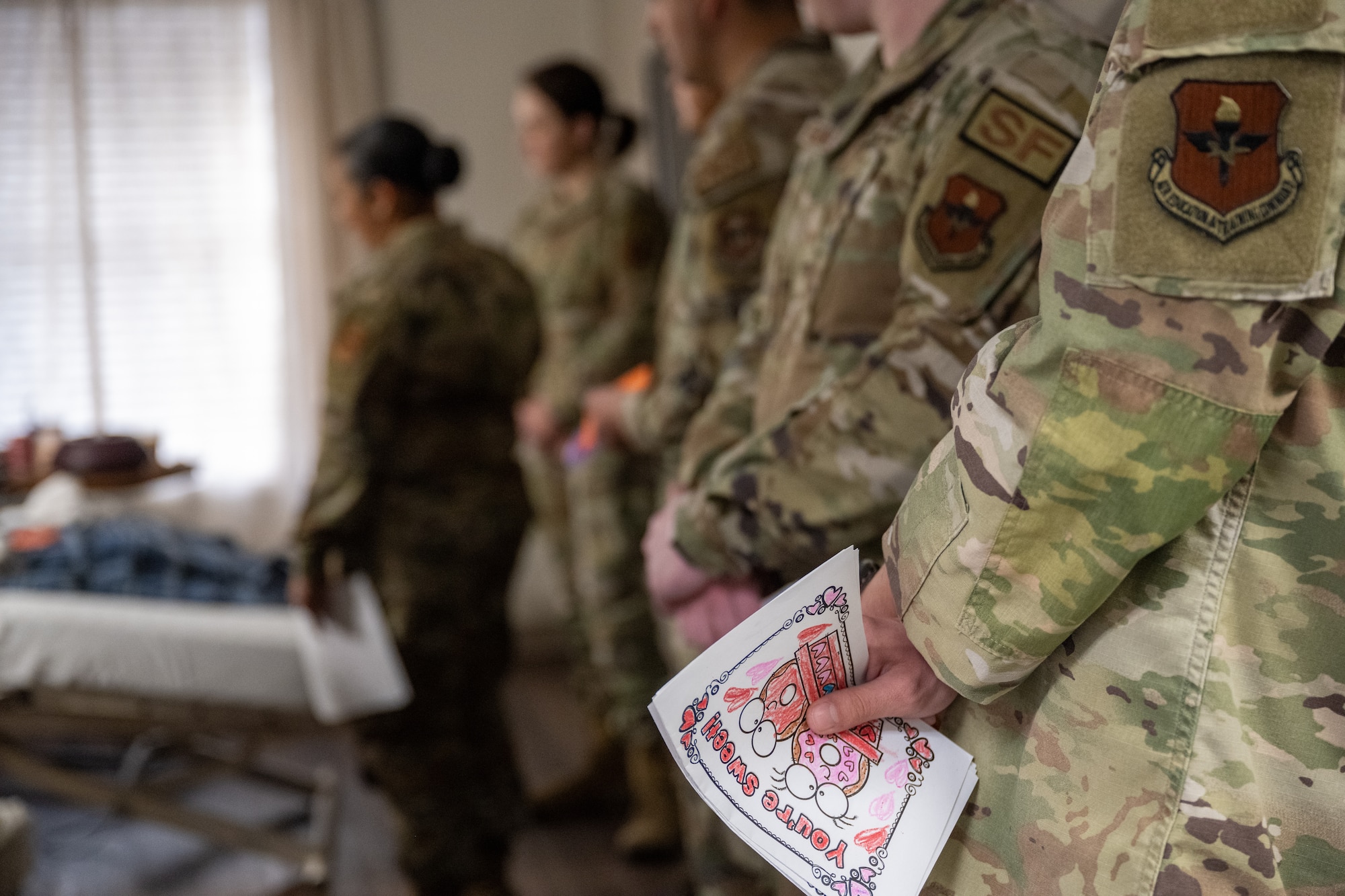 A resident of The Courtyards at Magnolia receives a valentine’s day card from a U.S. Air Force Airman in Altus, Oklahoma, Feb. 10, 2026. The card was part of a volunteer outreach effort to share appreciation with local residents and veterans and strengthen community connections. (U.S. Air Force photo by Airman 1st Class Nathan Langston)