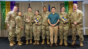 Group stand on stage to present.