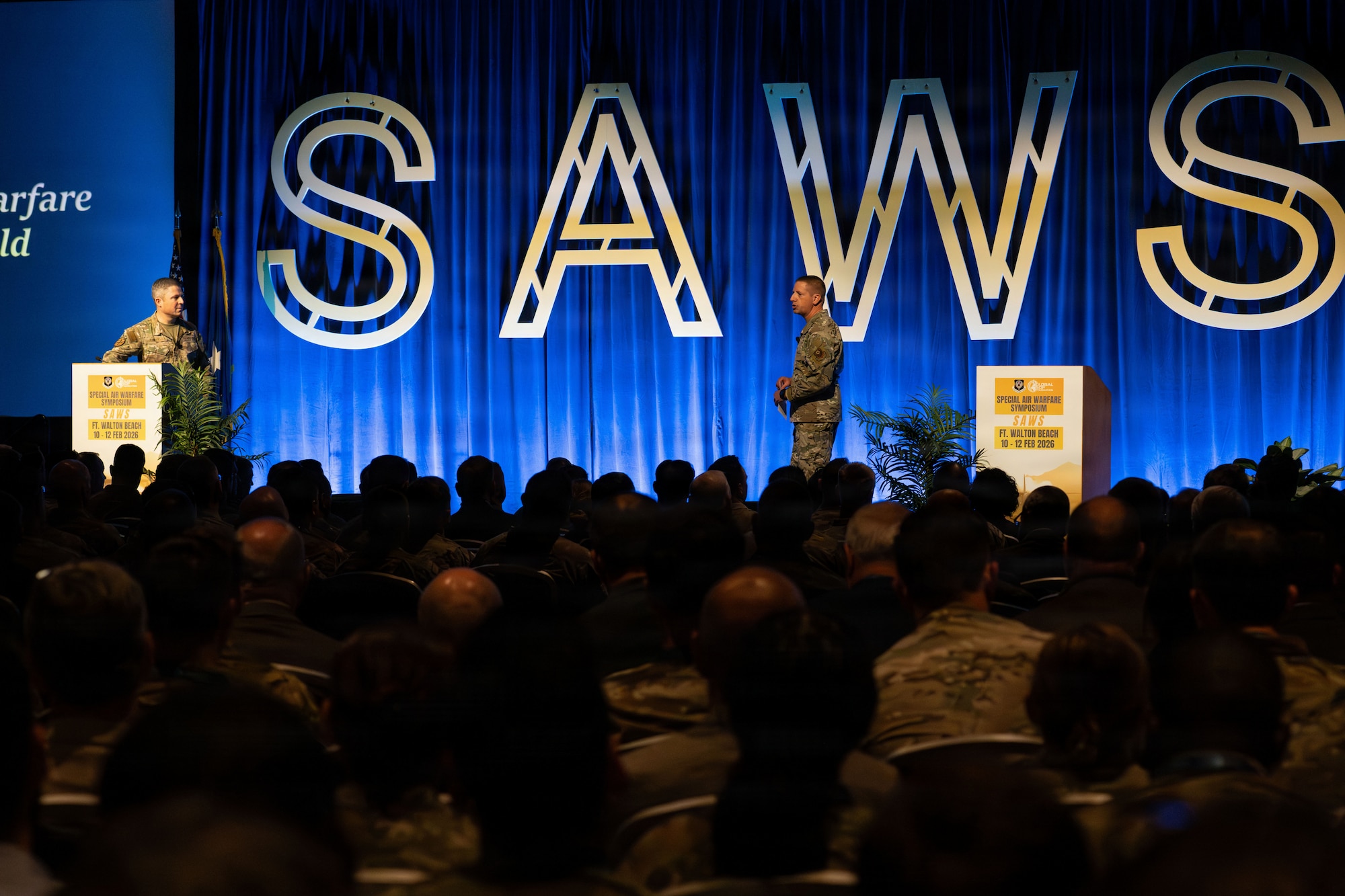U.S. Air Force Lt. Gen. Mike Conley, left, Air Force Special Operations Command commander, and Chief Master Sgt. Courtney Freeman, right, AFSOC command chief, deliver the opening keynote during the annual Special Air Warfare Symposium and Expo (SAWS) in Fort Walton Beach, Florida, Feb. 11, 2026