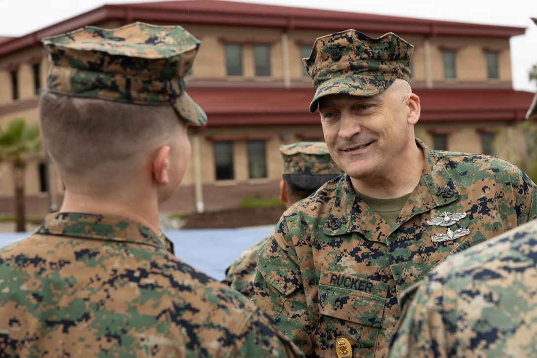 U.S. Navy Master Chief Rucker, command master chief, I Marine Expeditionary Force, left, presents a challenge coin to a Marine during a coin presentation and recognition ceremony at Marine Corps Base Camp Pendleton, Calif., Feb. 11, 2026. The ceremony recognized more than 30 Marines and Sailors for their hard work and dedication during the preparation and execution of the 250th Amphibious Capabilities Demonstration and Beach Bash held Oct. 18, 2025. (U.S. Marine Corps photo by Sgt. Buck)