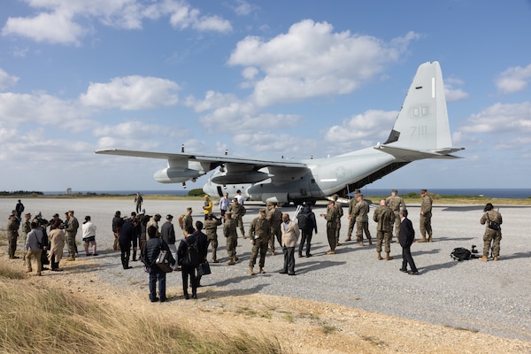 U.S. Marines and senior leaders assigned to III Marine Expeditionary Force and Marine Corps Installations Pacific, officials of the Okinawa Defense Bureau, and local news reporters observe a KC-130J Super Hercules at Ie Shima Training Facility, Okinawa, Japan, Dec. 15, 2025.